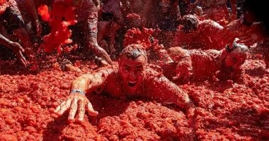 بيحدفوا طماطم على بعض.. آلاف الأشخاص يشاركون بمهرجان لاتوماتينا بإسبانيا